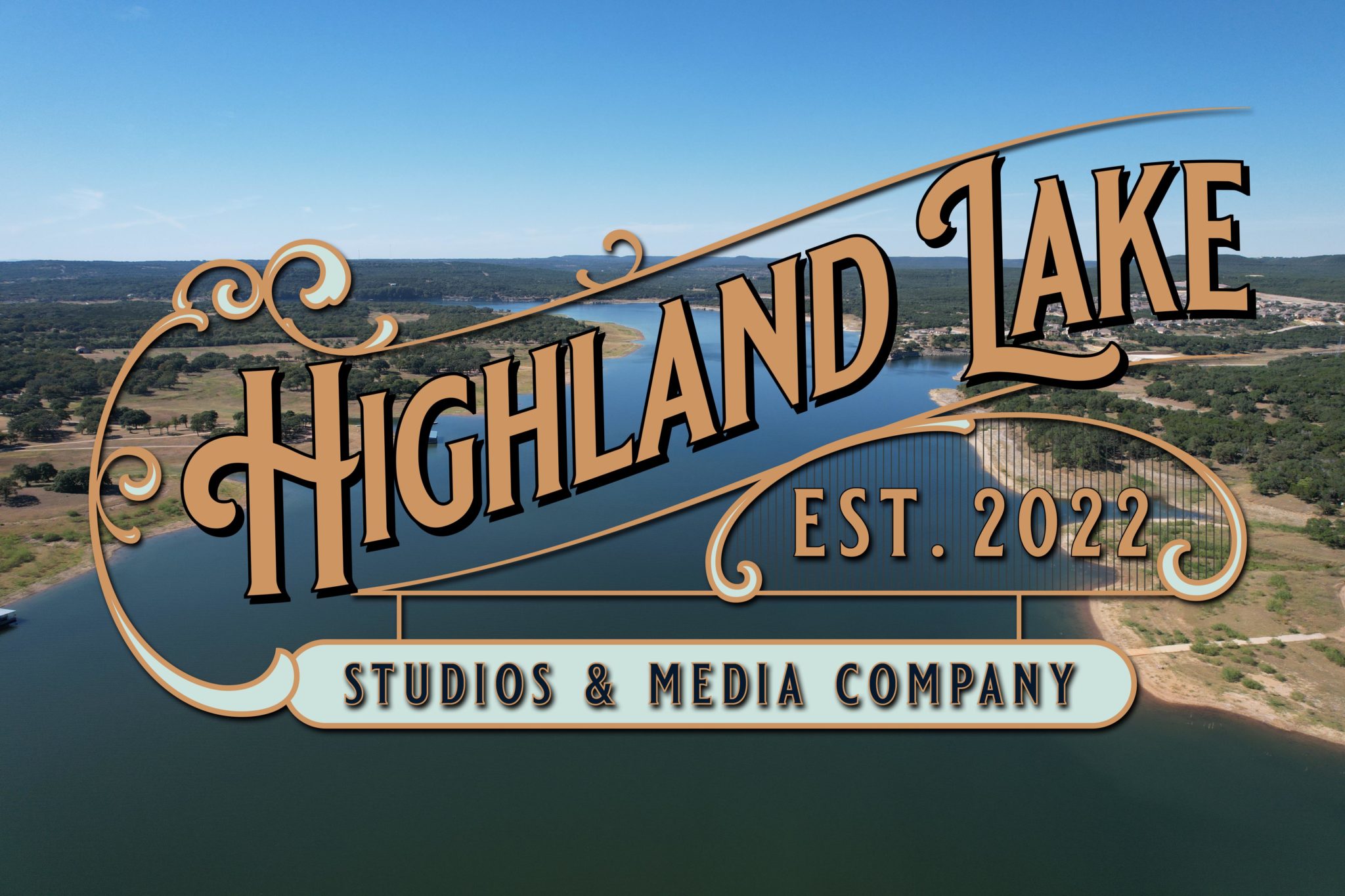 Highland Lake Studios & Media Company, established 2022, with copper lettering over an aerial photograph of the lake.